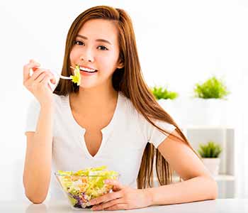 Young lady eating healthy foods for caring teeth
